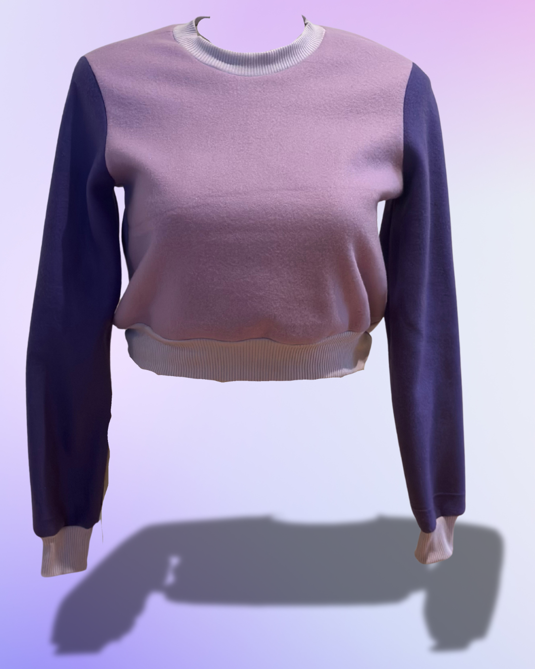 Two-tone sweater with purple sleeves and pink body on a light purple background